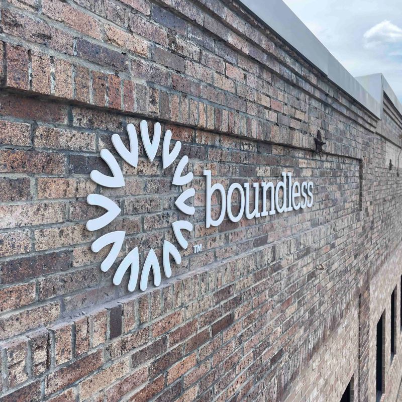 Dimensional logo lettering mounted to a brick wall.