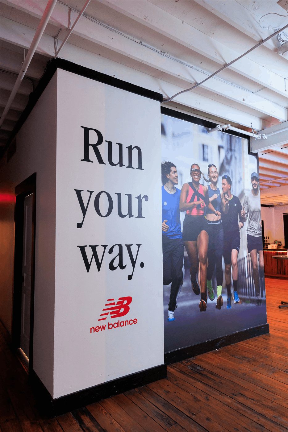 Large New Balance event wall graphics inside a venue.