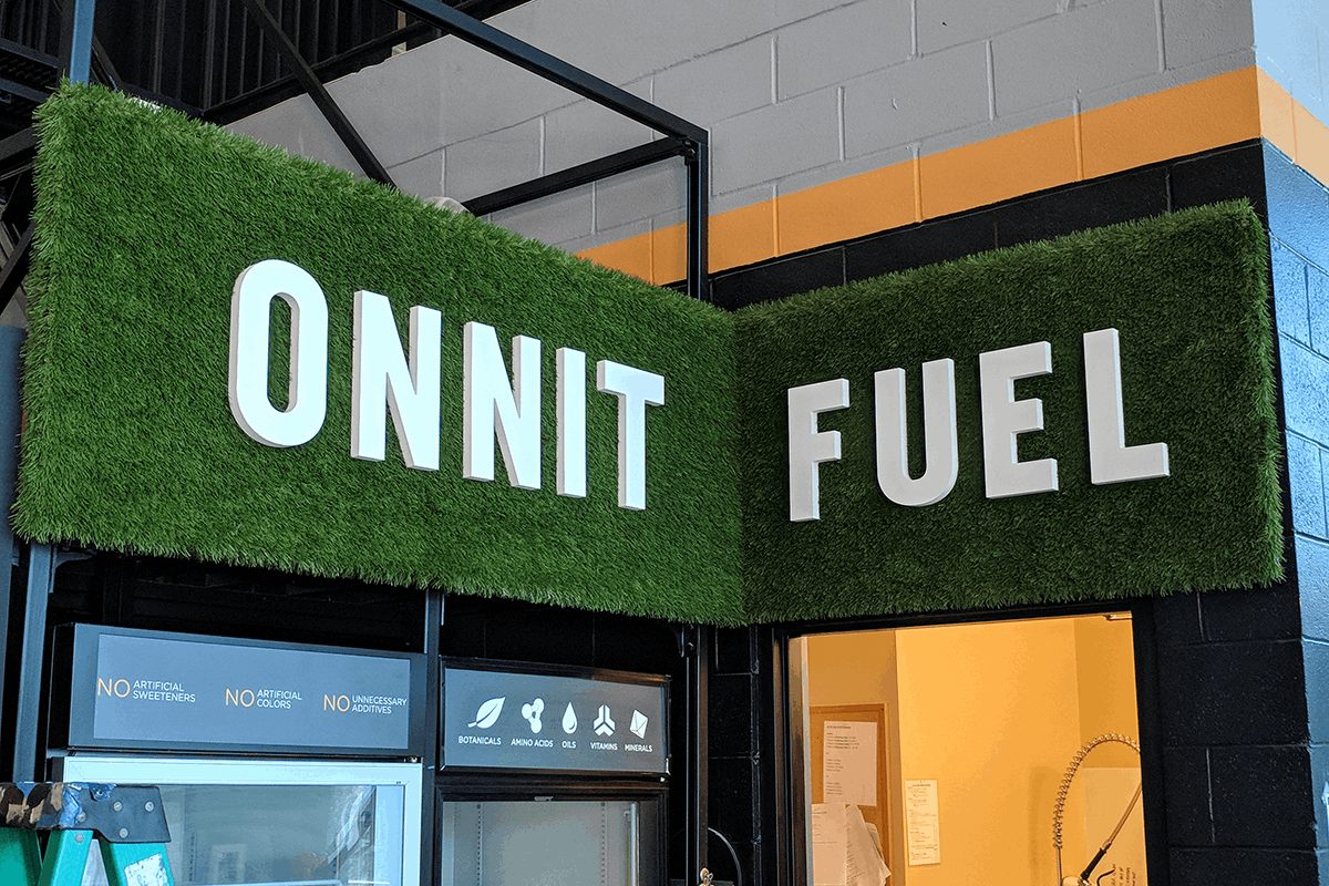 Dimensional letters mounted to a textured green wall.