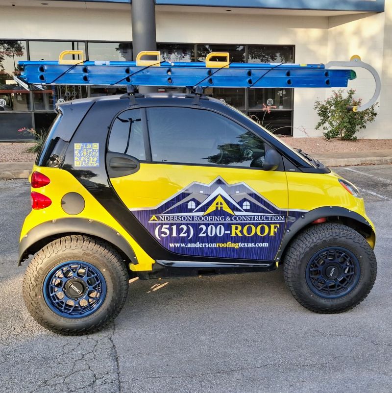 Anderson Roofing branded small vehicle with door and side graphics.